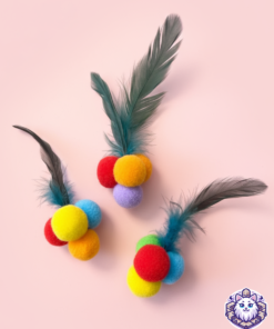 juguetes de pompones de colores con plumas sobre un fondo rosa.