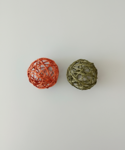 dos pelotas de hilo de papel para gato (naranja y verde) sobre fondo limpio.